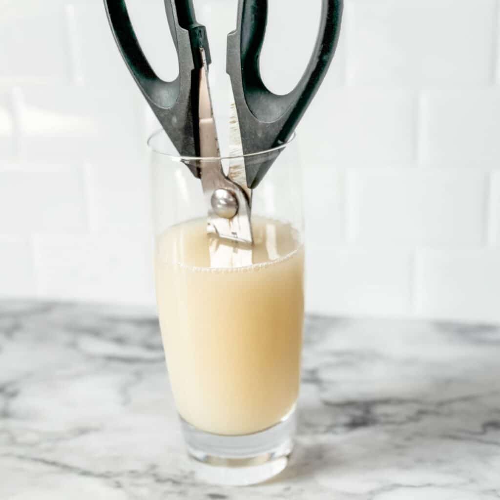 rusty scissors in a glass of lemon juice