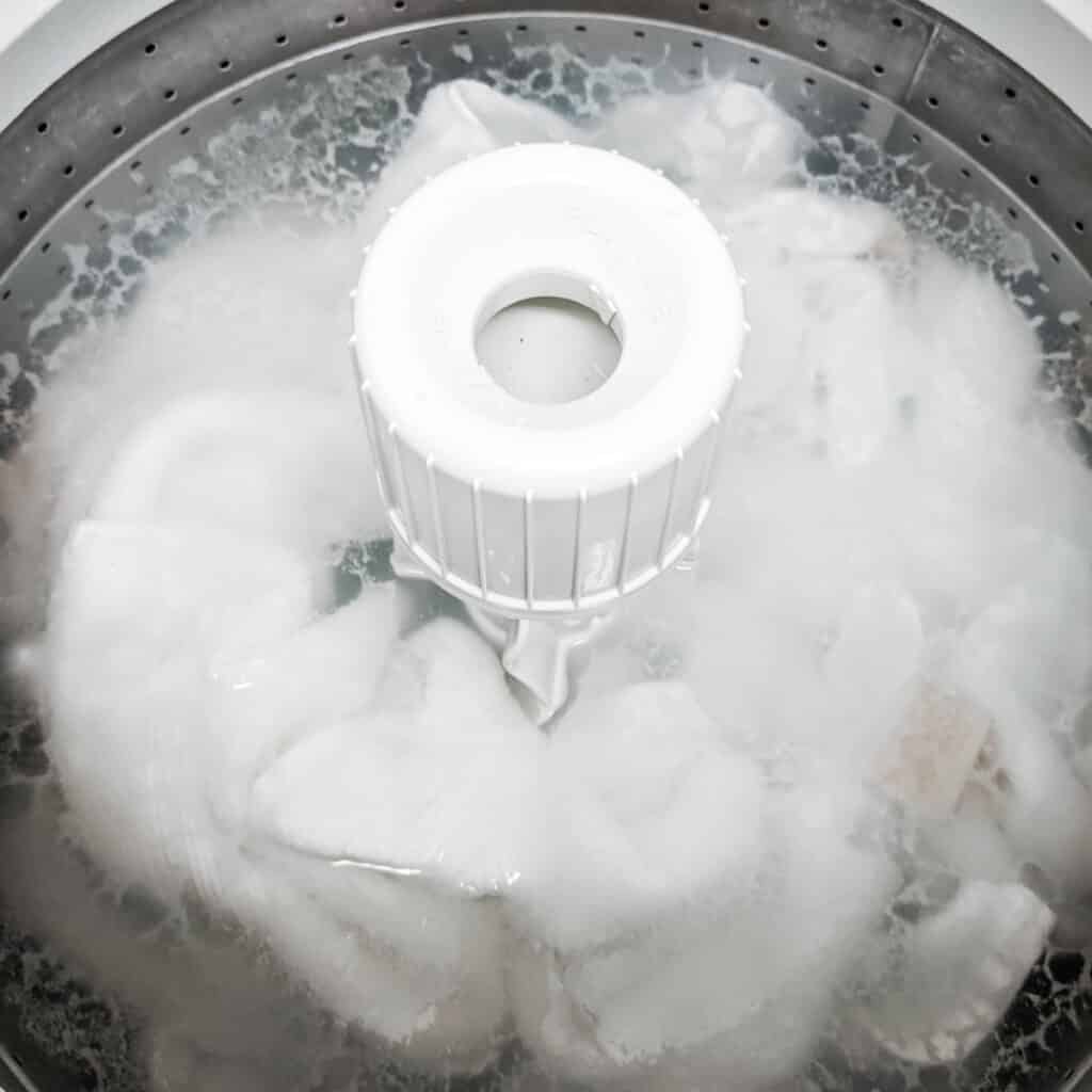 Soaking clothes in vinegar in the washing machine to remove mildew.