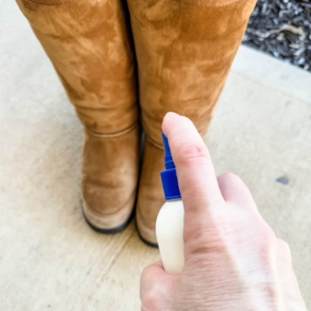 spraying sheepskin boots with a protectant