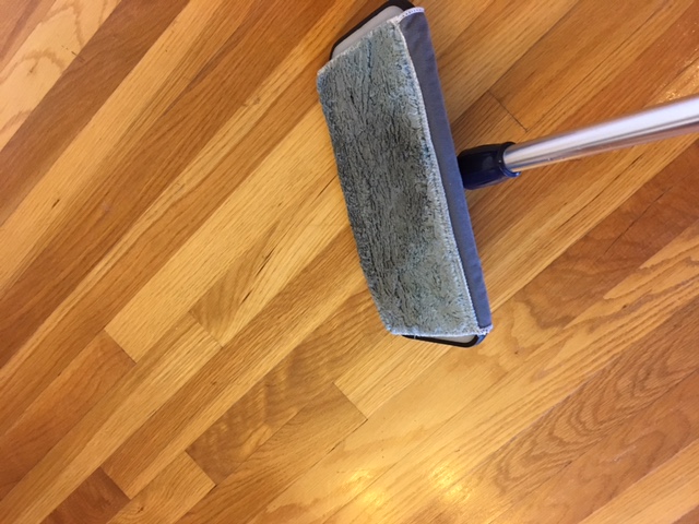 wet mop being used to remove dust and grime from hardwood floors