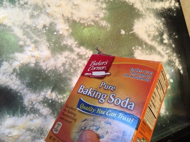 Sprinkling baking soda over the top of the dirty oven glass door.