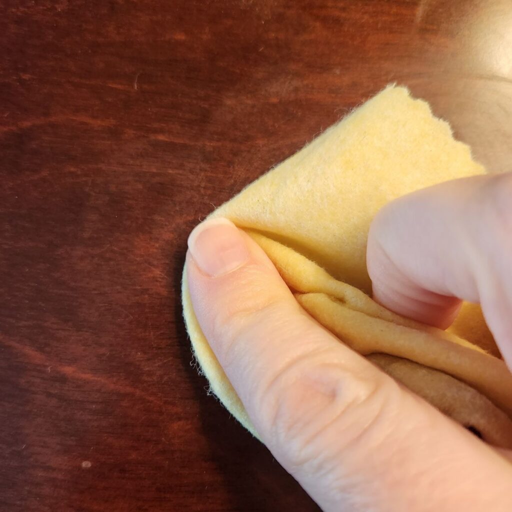 rubbing the heat stain remover into the wood