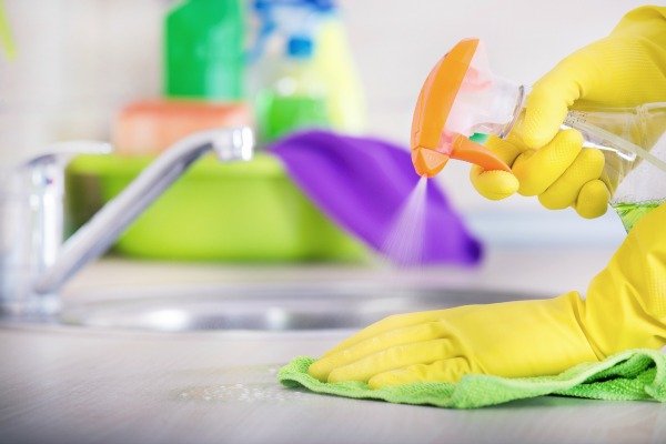 spraying countertop with rubbing alcohol