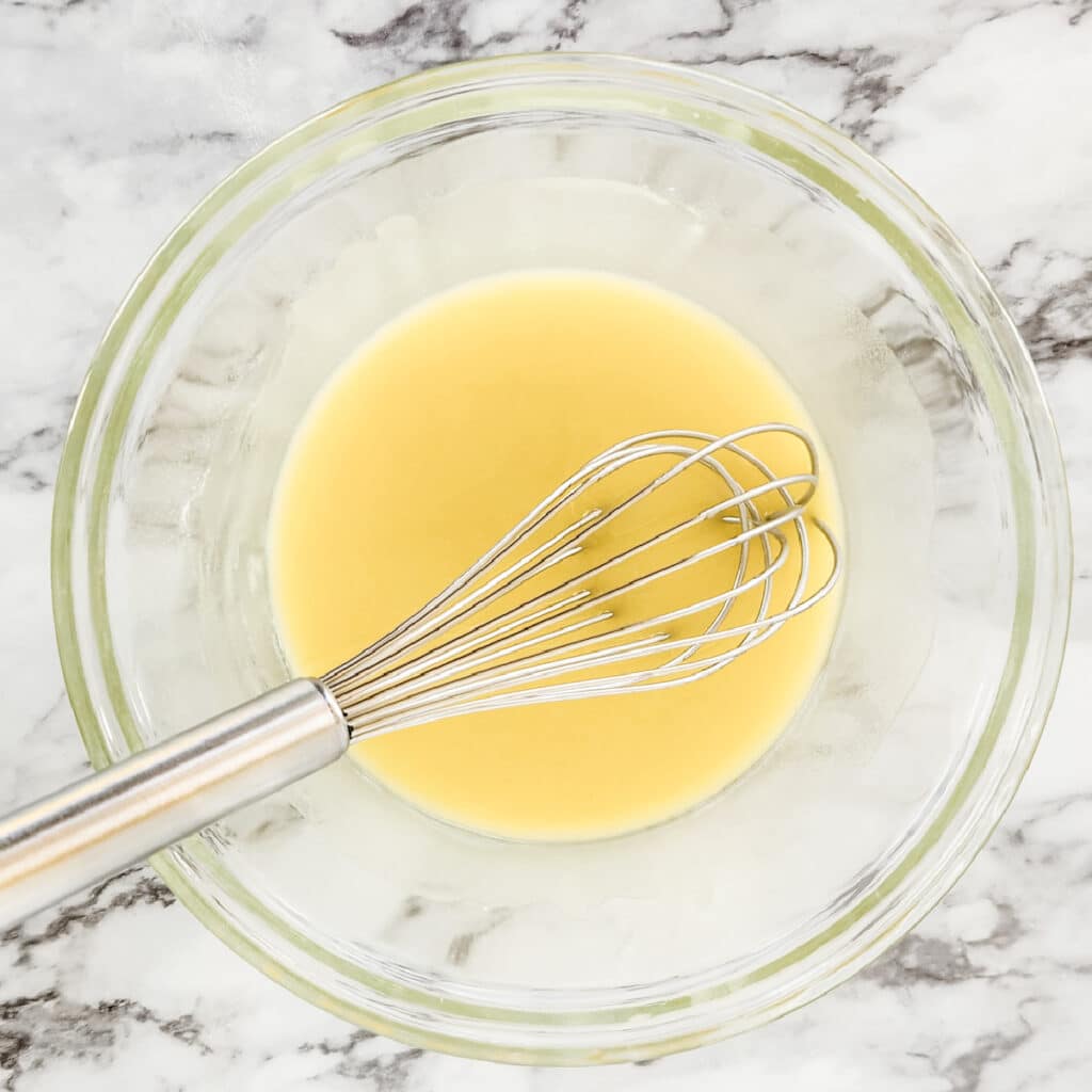 Whisking the oil and baking soda together in a glass bowl.