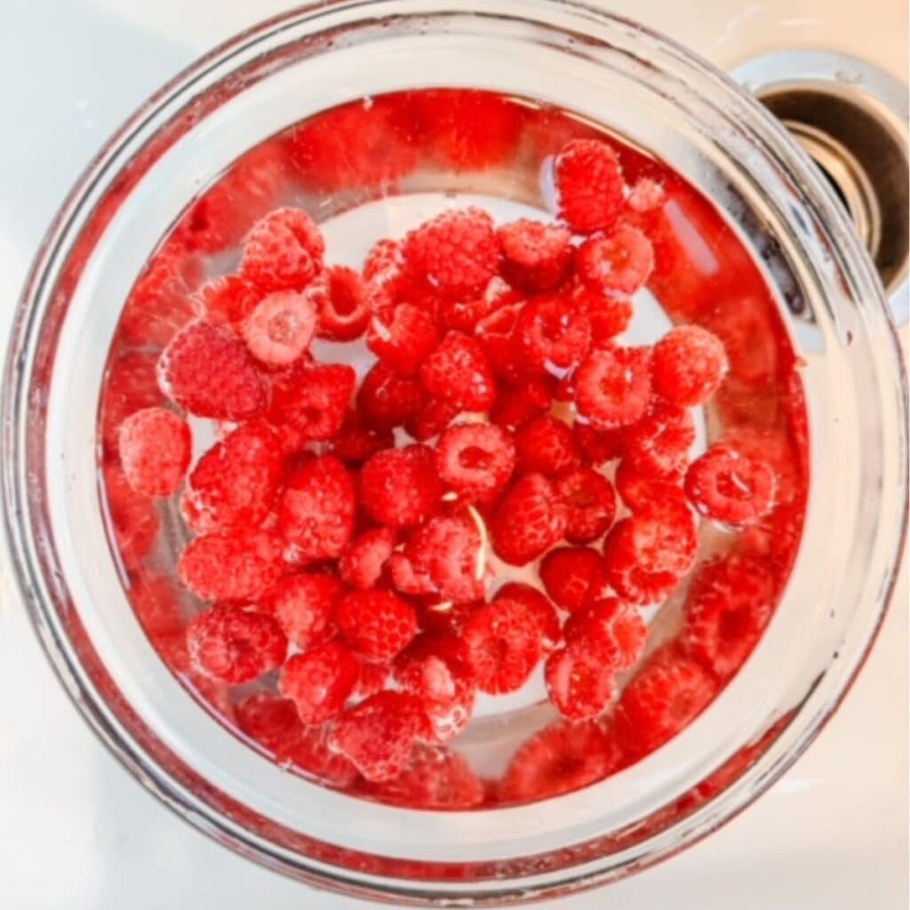 fresh raspberries in the sink getting cleaned